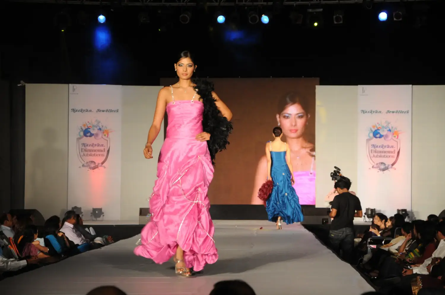 Balloon arch in orange, black, and white colors framing an ITT logo board lit with warm lights